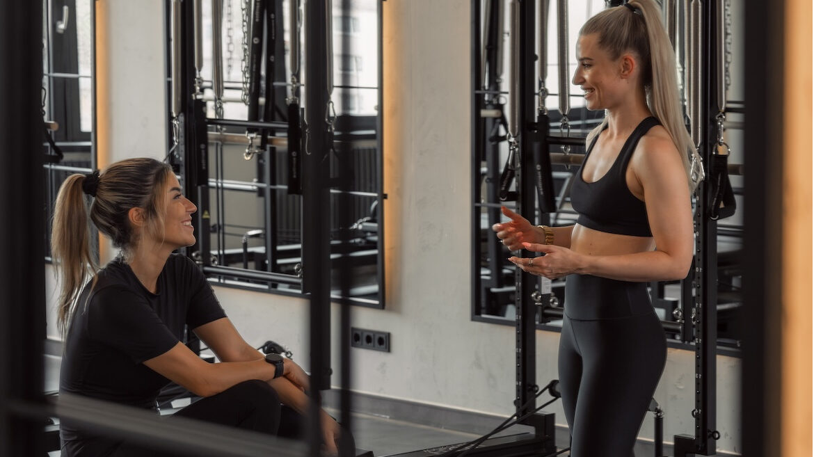 rainerin im pers&ouml;nlichen Gespr&auml;ch mit einer Teilnehmerin im Reformer-Pilates-Studio Flow your core in Markkleeberg